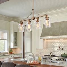 a kitchen island with four lights hanging over it