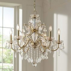 a chandelier hanging from a ceiling in a room with white walls and windows