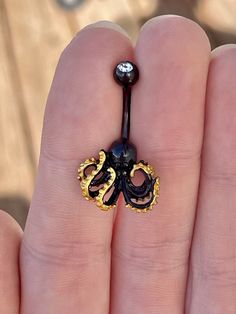 This octopus/kraken belly button ring is unique but elegant with a solid black color and gold details. Drop jaws with this navel jewelry! Details & Size: ♥ 316L Surgical Steel ♥ 10mm bar, 14G ♥ Externally Threaded ♥ Every purchase comes with an Elara gift box For sanitary purposes, piercing items are non-returnable, so please double check sizing and message me if you have any questions! Belly Button Piercing Jewelry Unique, Navel Piercing Plus Size, Black Belly Button Piercing, Bellybuttonpiercing Jewelry, Belly Button Piercing Black, Ashley Piercing Jewelry, Double Belly Piercing, Belly Button Piercing Cute, Unique Belly Rings