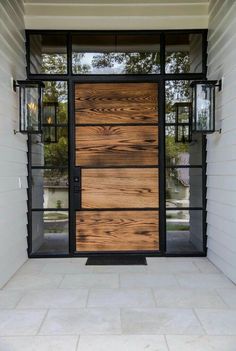 the front door is made out of wood and glass