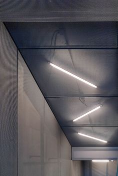 an empty hallway with lights on the ceiling