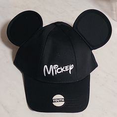 a black mickey mouse hat with the word mickey on it's front and side