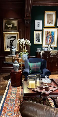 a living room filled with furniture and pictures on the wall next to a coffee table