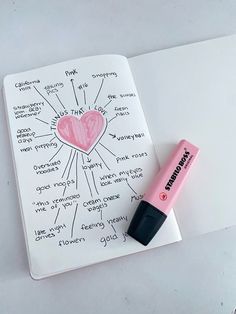 a pink marker sitting on top of a notebook