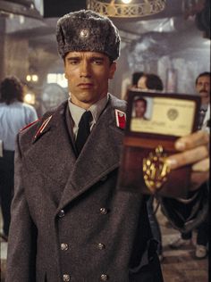 a man in uniform holding up an award for his work on the great gats