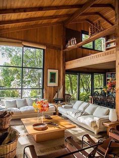 a living room filled with lots of furniture next to large window covered in wood planks