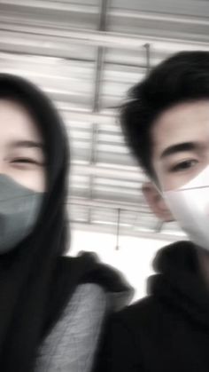 two people wearing face masks while standing next to each other