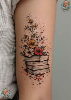 a woman's arm with flowers and books on it