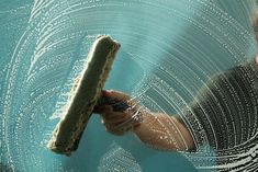 a person holding a piece of food in their hand with water droplets on the surface