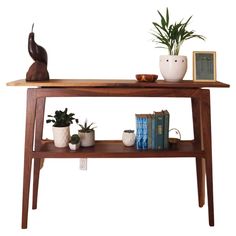 a wooden table with books and plants on it