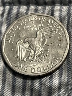 an old one dollar coin with the eagle on it