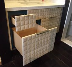 a bathroom vanity with two drawers and a sink in the corner, all made out of cardboard