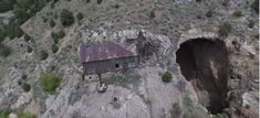 an aerial view of a house built into the side of a mountain with a hole in it