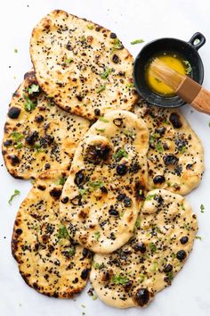 flat bread with olives and oil on a white surface