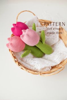 three crocheted flowers sitting in a basket on top of a white doily