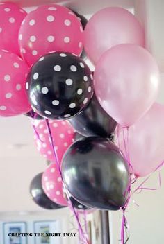 a bunch of balloons that are on top of a pole in front of a door