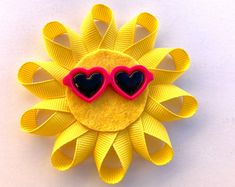 a sunflower brooch with two heart shaped glasses on it's center piece