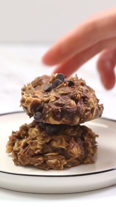 two cookies stacked on top of each other with chocolate chips and oats in the middle