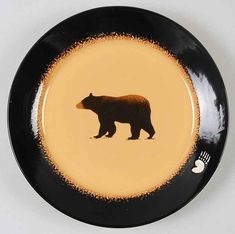 a black and yellow plate with a brown bear on the side, in front of a white background