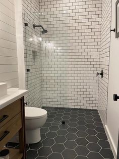 a white toilet sitting next to a walk in shower