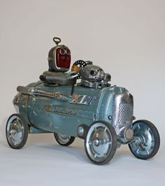 an old fashioned toy car with a robot on top