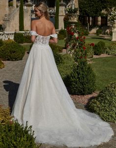a woman in a wedding dress standing outside