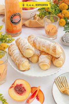 peaches and croissants on a white plate with orange juice in the background