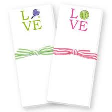 two folded cards with the words love and tennis balls on them, tied to each other