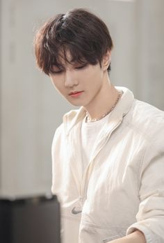 a young man wearing a white shirt is playing the piano