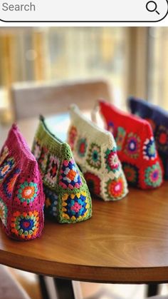 several crocheted purses sitting on top of a wooden table