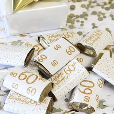 white and gold 50th birthday party favors with confetti wrappers on the table