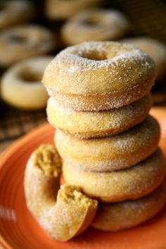 a stack of doughnuts sitting on top of an orange plate