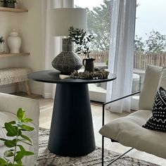 a living room filled with furniture and a lamp on top of a table next to a window