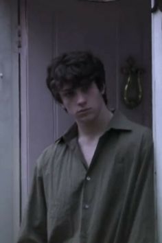 a young man standing in front of a door