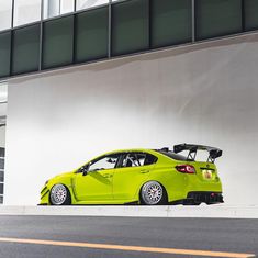a bright green car parked in front of a building