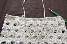 a crocheted purse with a green handled knitting needle