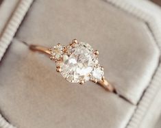 an engagement ring with three diamonds in it on top of a cushioned box,