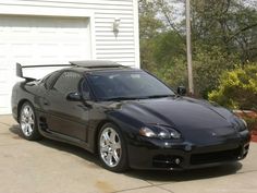 a black sports car parked in front of a garage