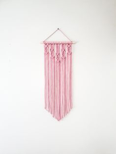 a pink wall hanging on a white wall