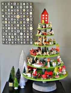 a christmas tree made out of toy figurines on a table in front of a magnet board