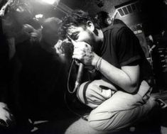 a black and white photo of a man holding a microphone