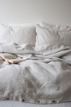 an unmade bed with a book on it