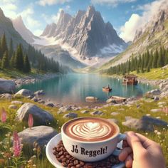 someone holding a cup of coffee in front of a mountain lake