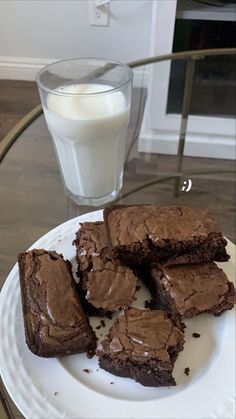 chocolate brownies on a plate with a glass of milk