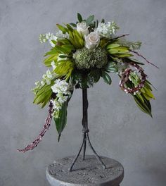 a vase with flowers and greenery in it