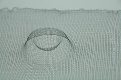 an object is shown in the shape of a circle on a piece of mesh fabric