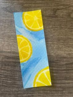 a piece of paper that has been painted with lemons and blue sky in the background