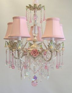 a chandelier with pink shades and flowers on it