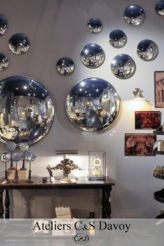 mirrors are hanging on the wall above a table