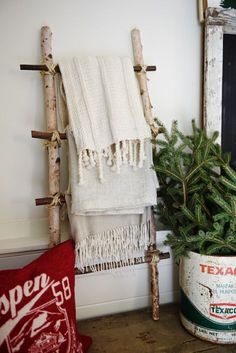 a christmas tree in a bucket next to a towel rack